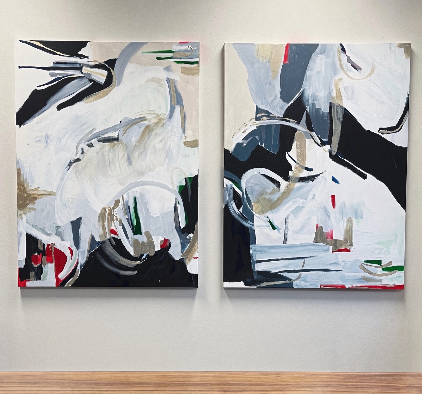Two large abstract acrylic paintings in black, white, red, and grey hanging side by side
